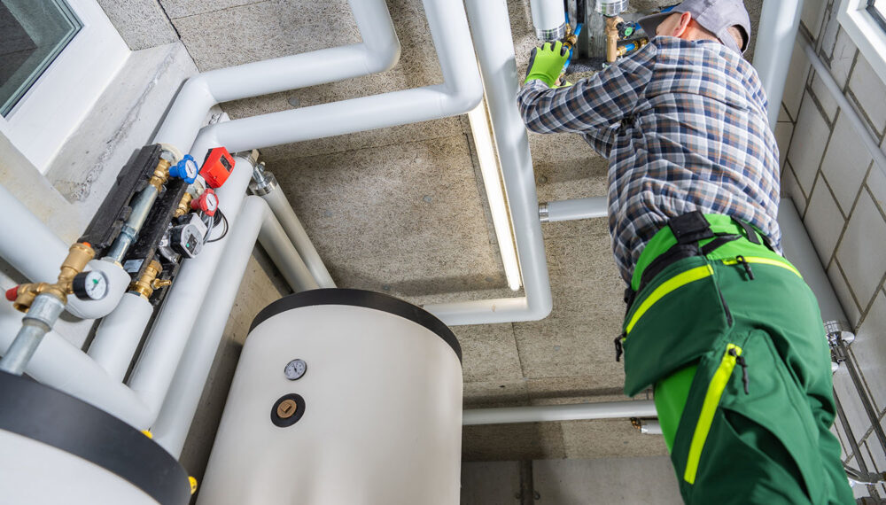 Residential and Commercial Modern Natural Gas Heating Systems Installation Performed by Professional Caucasian HVAC Technician in His 40s.